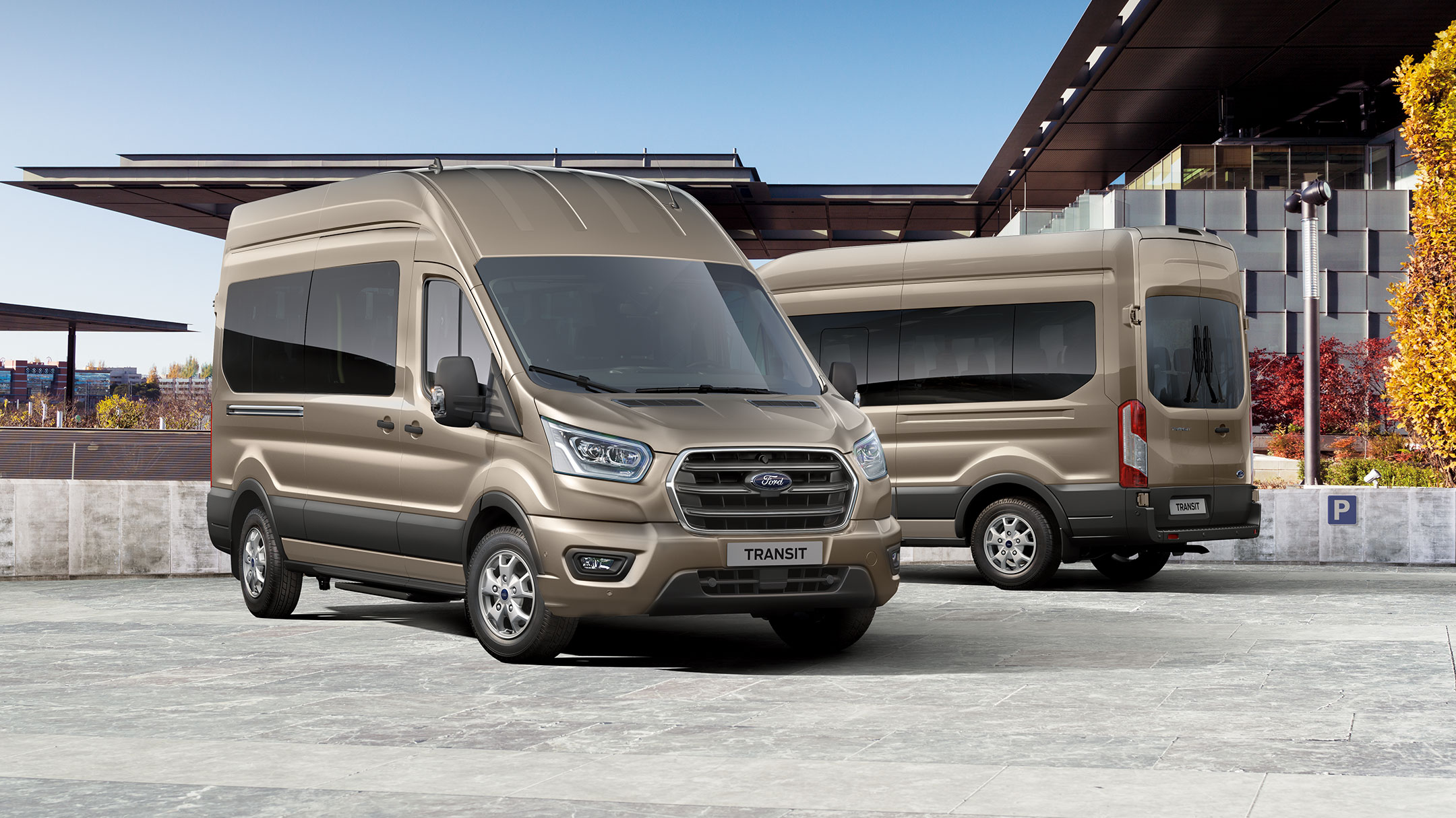 Two gold Ford Transit Minibuses parked side by side